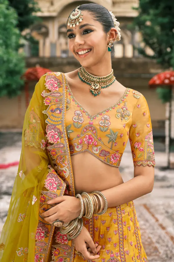 Flat lay of yellow silk lehenga with cut work border detail