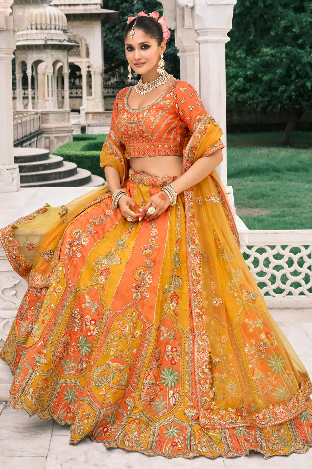 Close-up of mirror work on orange and yellow bridal lehenga