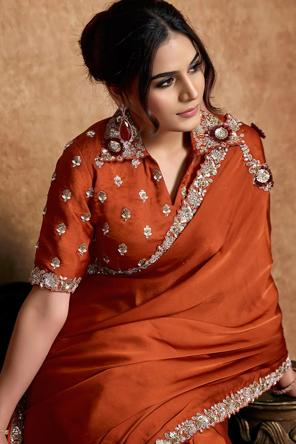 Model wearing rust orange festive saree with elegant styling