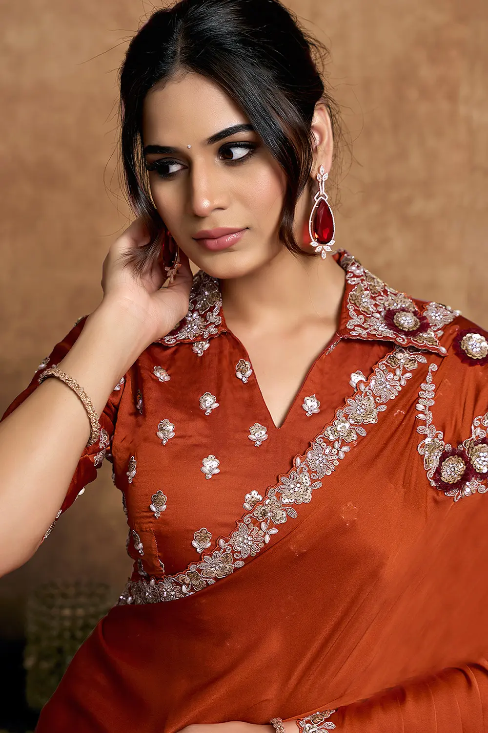 Close-up of floral applique work with pearls and stones on satin silk saree