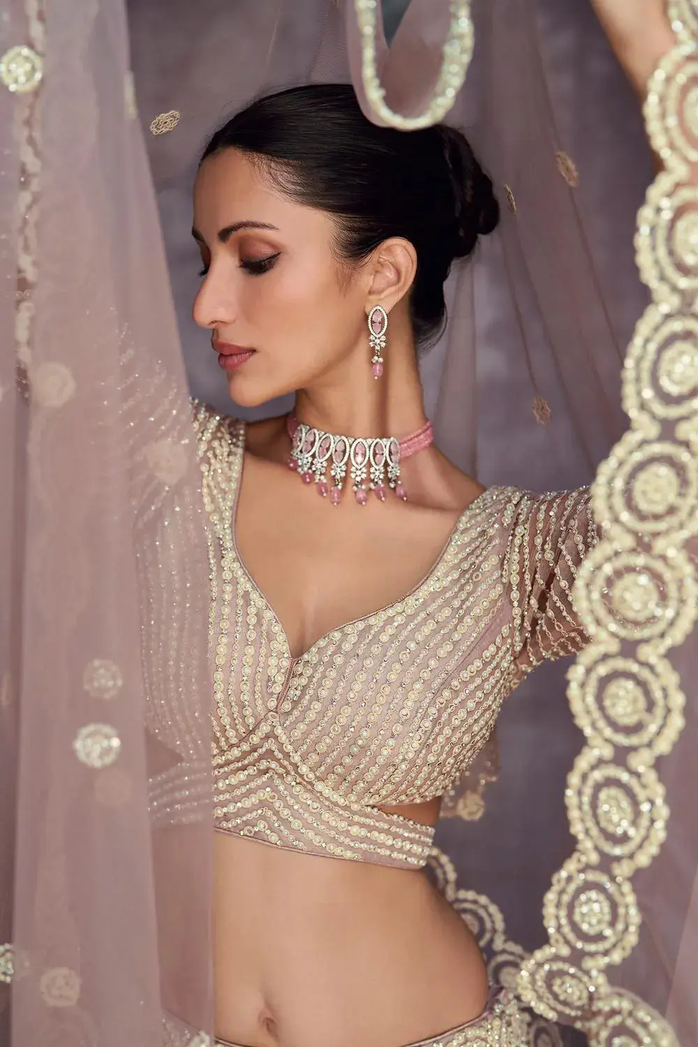 Macro shot of hand Moti and Seroski diamond work on the bridal lehenga fabric.