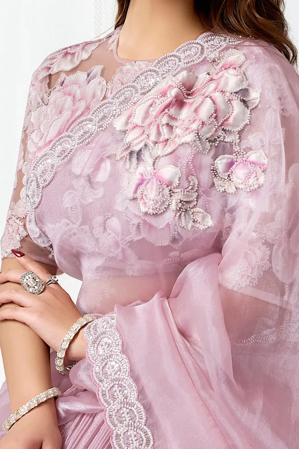 Side drape of pink fancy saree party wear showing hem embroidery