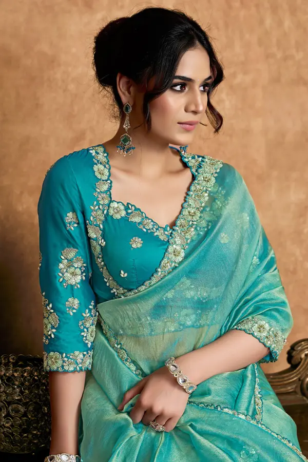Close-up of applique and stone detailing on turquoise saree