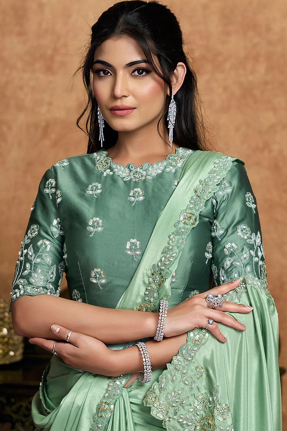 Close-up of pearl and sequin detailing on green saree