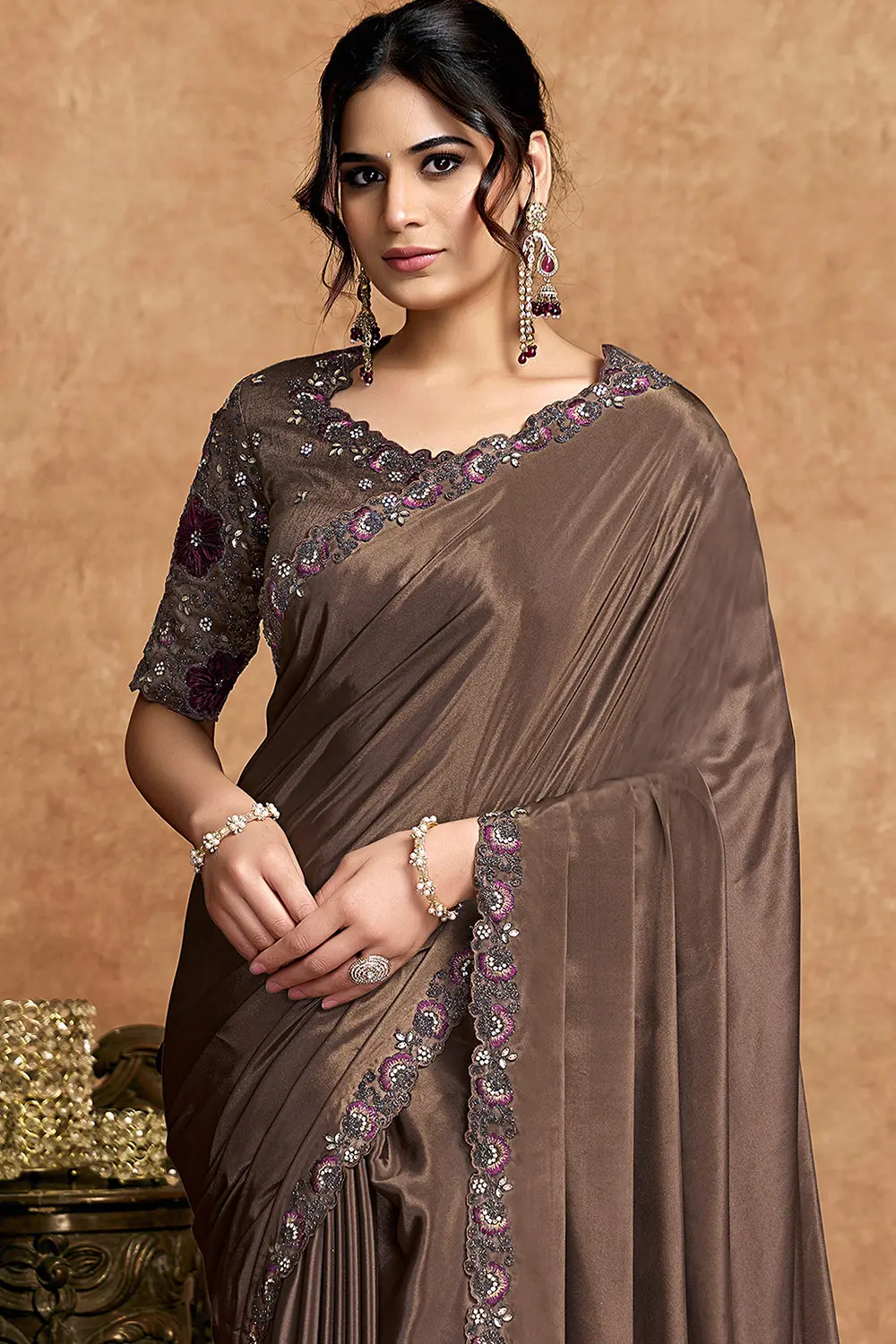 Close-up of stone and thread work detailing on brown saree