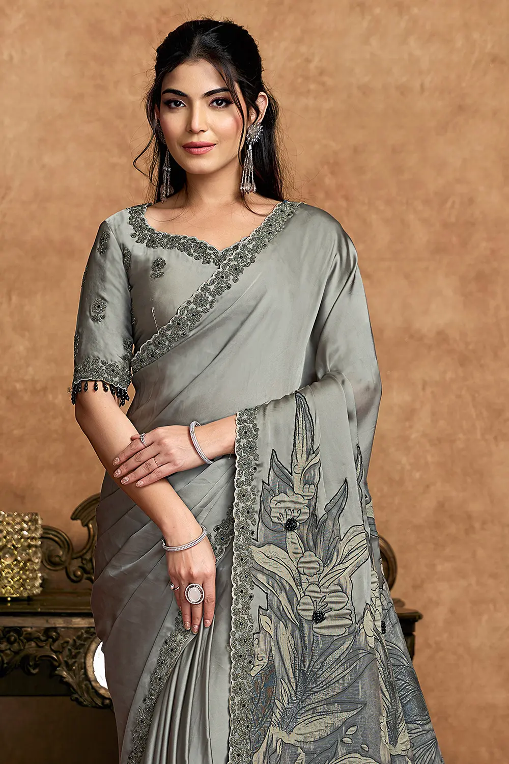 Close-up of black stone and pearl detailing on grey saree