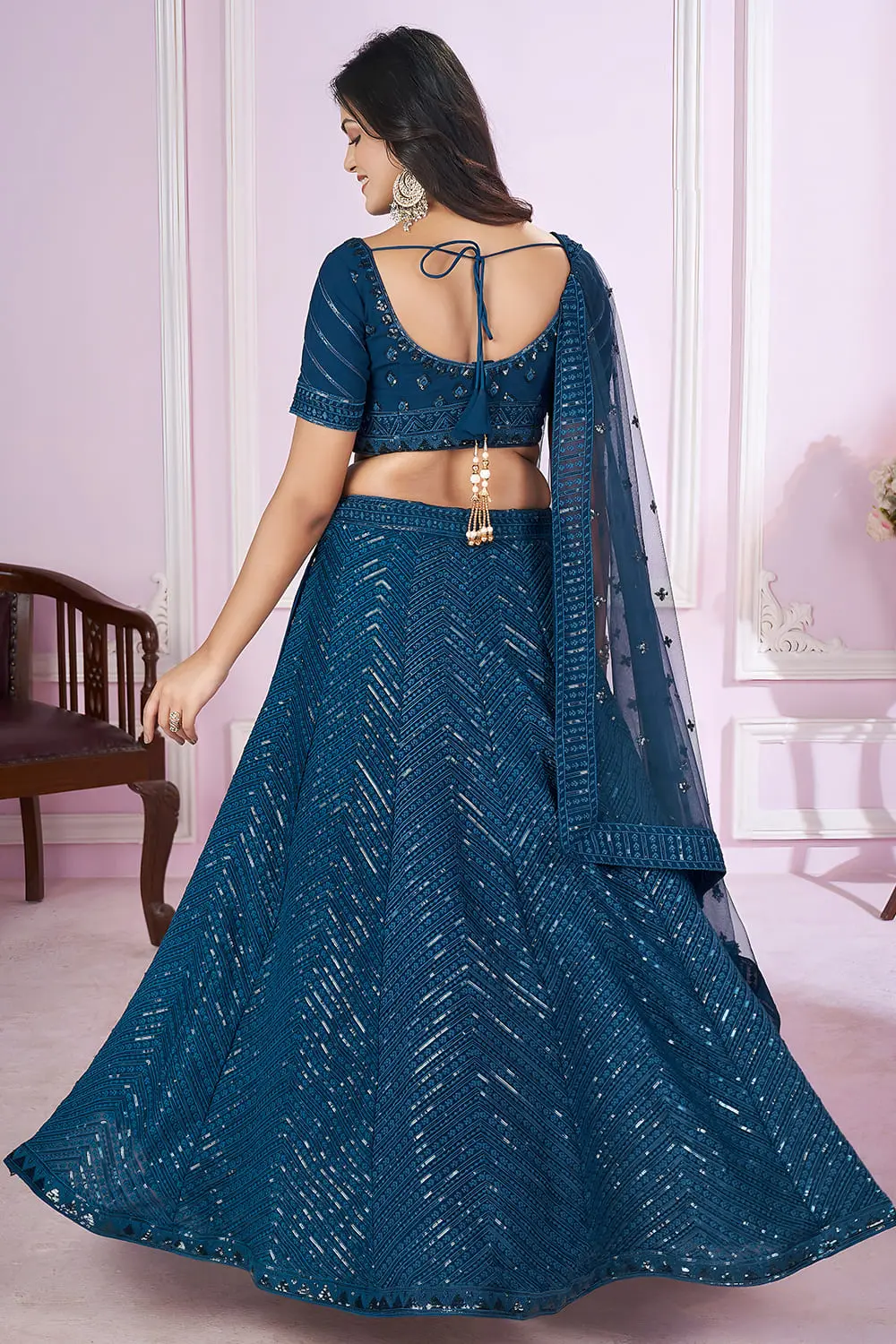 Back view of lehenga set with dupatta cascading and zari details on hemline