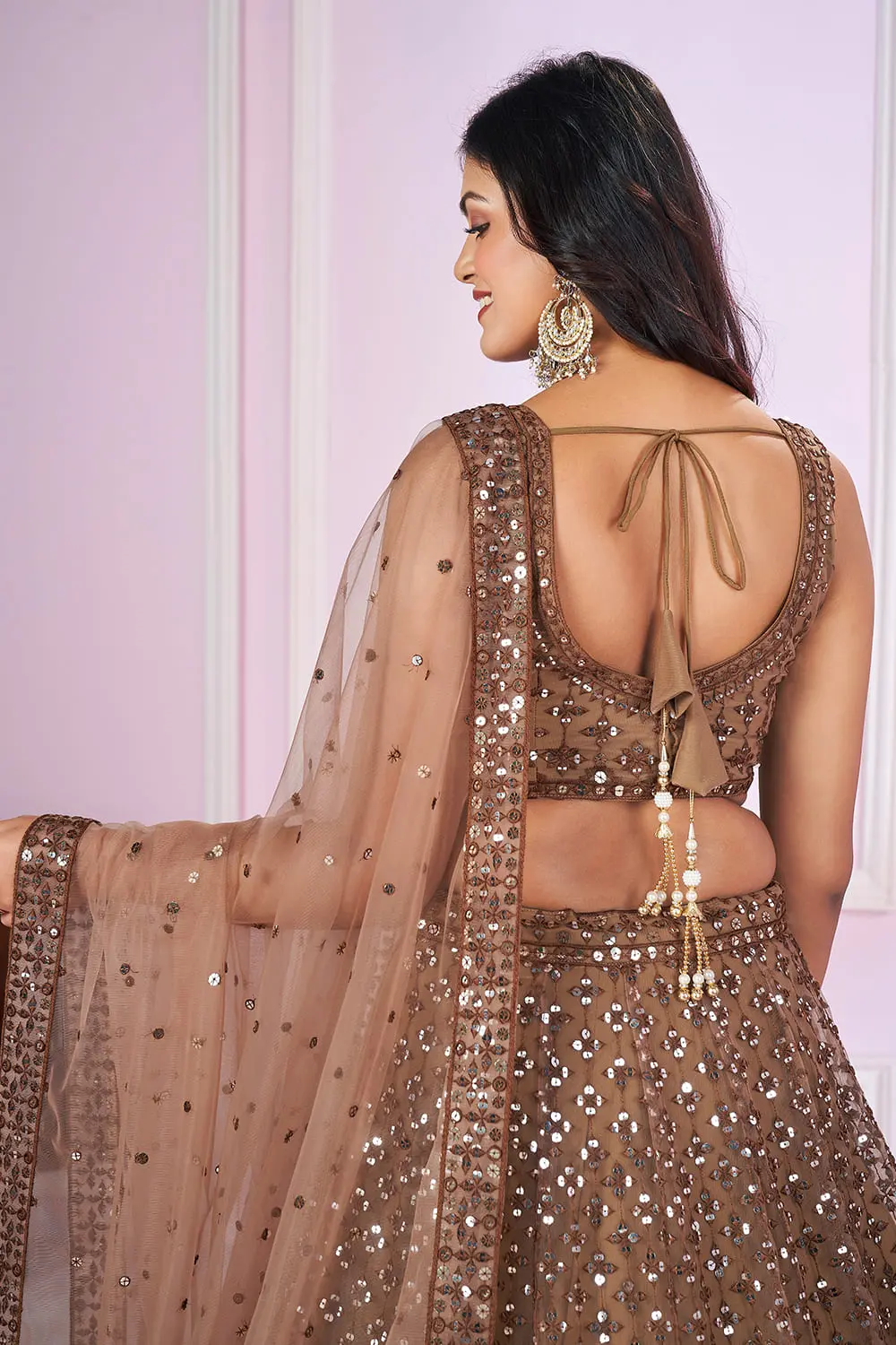 Model wearing brown lehenga dress for wedding reception at Khaish studio