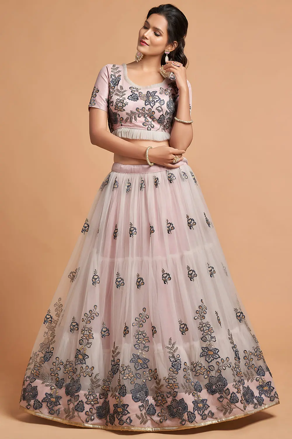 Side profile of a woman wearing the Grey Soft Net Lehenga with long sleeves blouse, dupatta draped elegantly.