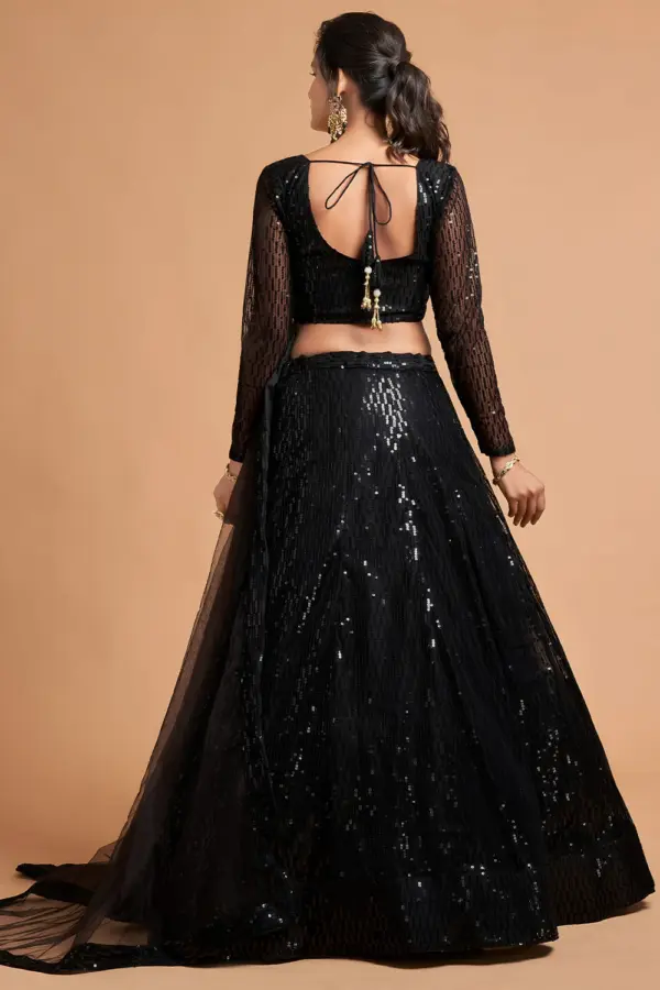 The Black Net Lehenga set displayed flat with dupatta, potli, and statement earrings.