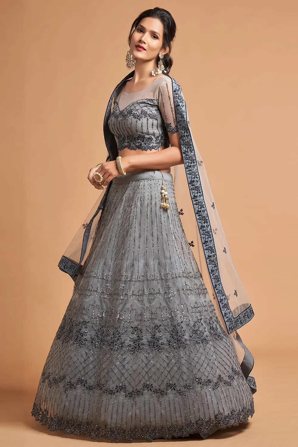 A woman twirling in the Light Grey Net Lehenga, capturing the airy movement of the net chaniya choli.