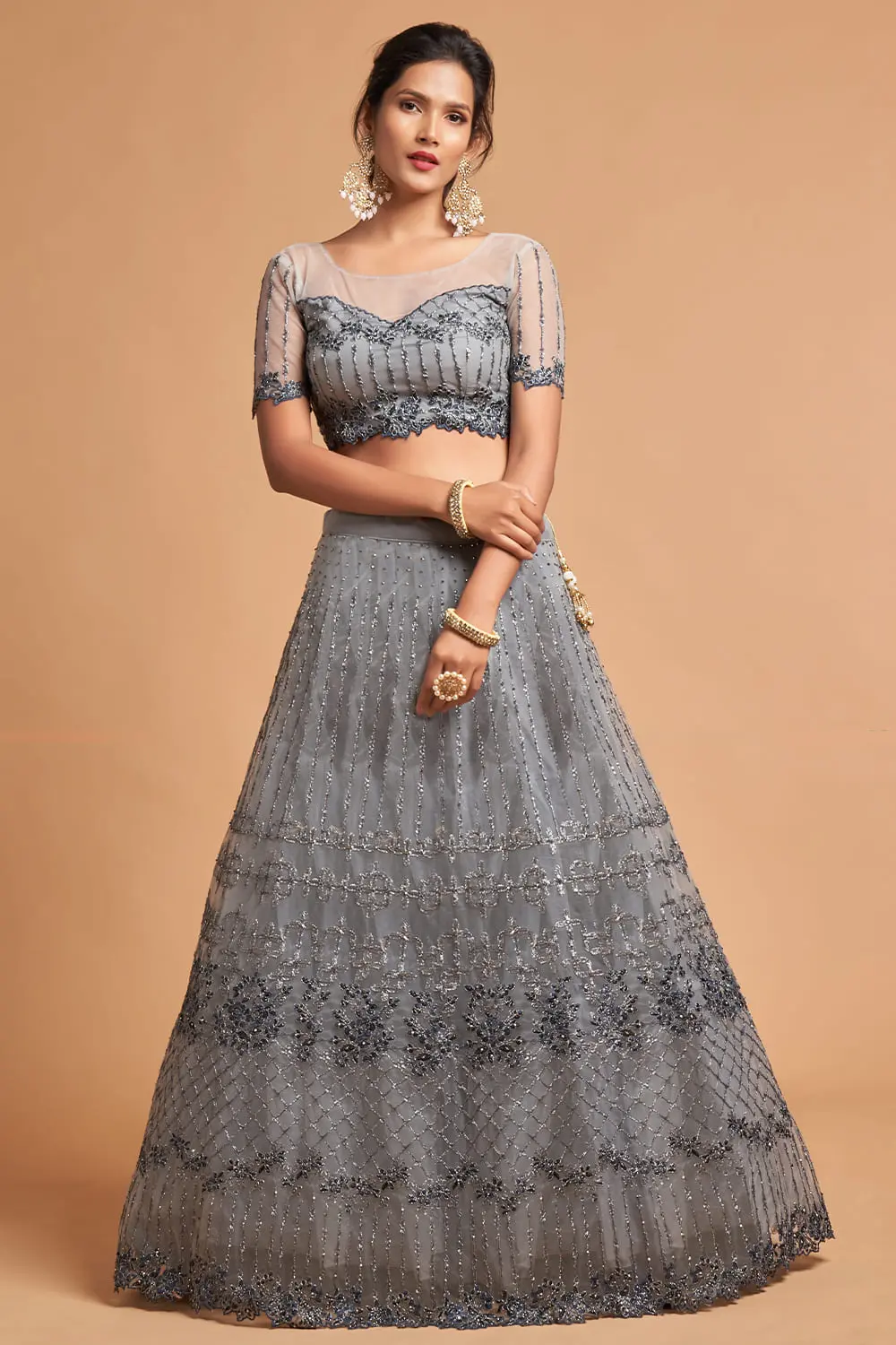Flat lay of the complete Light Grey Net Lehenga set with silver dupatta, pearl jewellery, and a clutch.