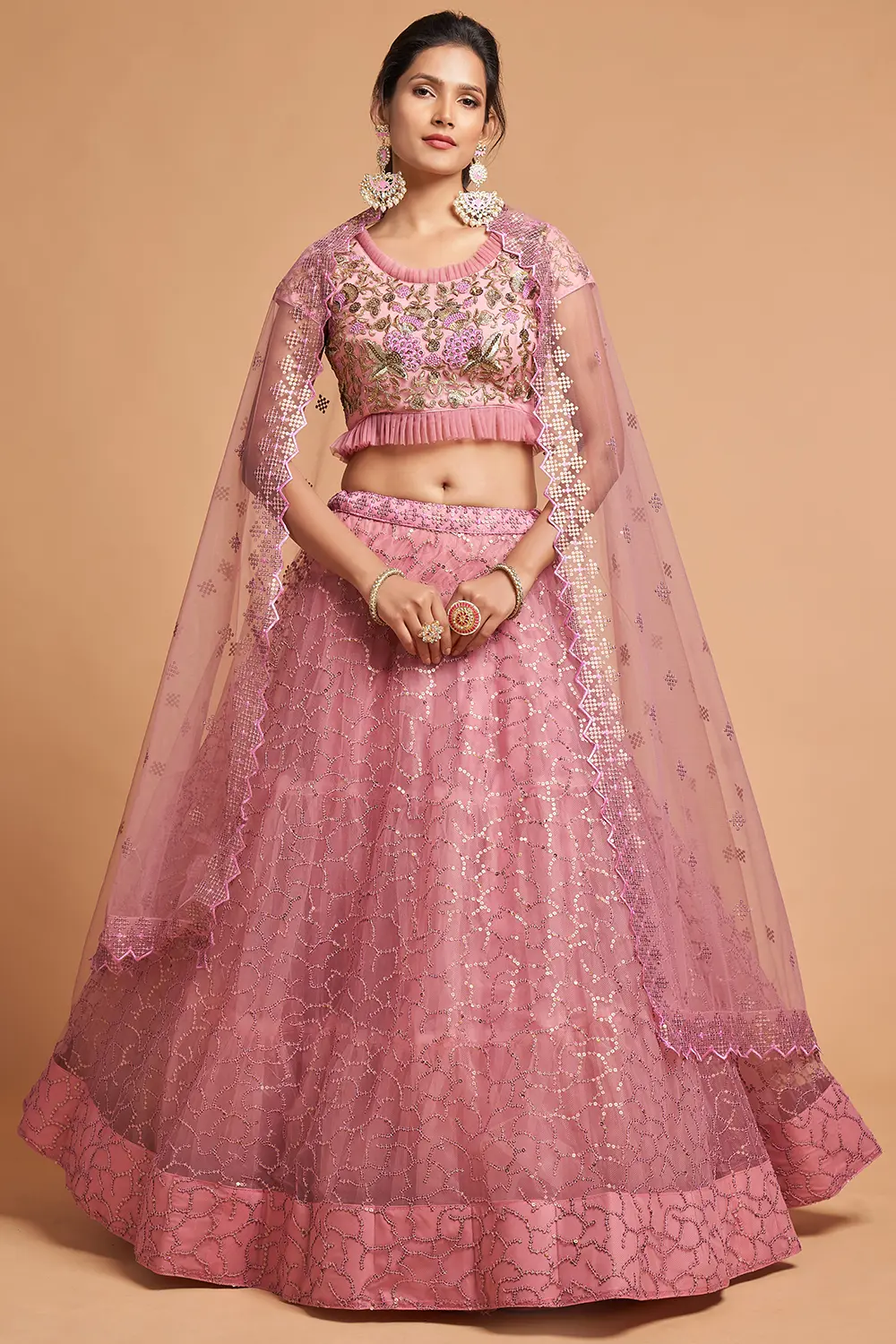 Flat lay of the Dusty Pink Net Lehenga set with a rose-gold dupatta, pearl kalire, and potli bag.