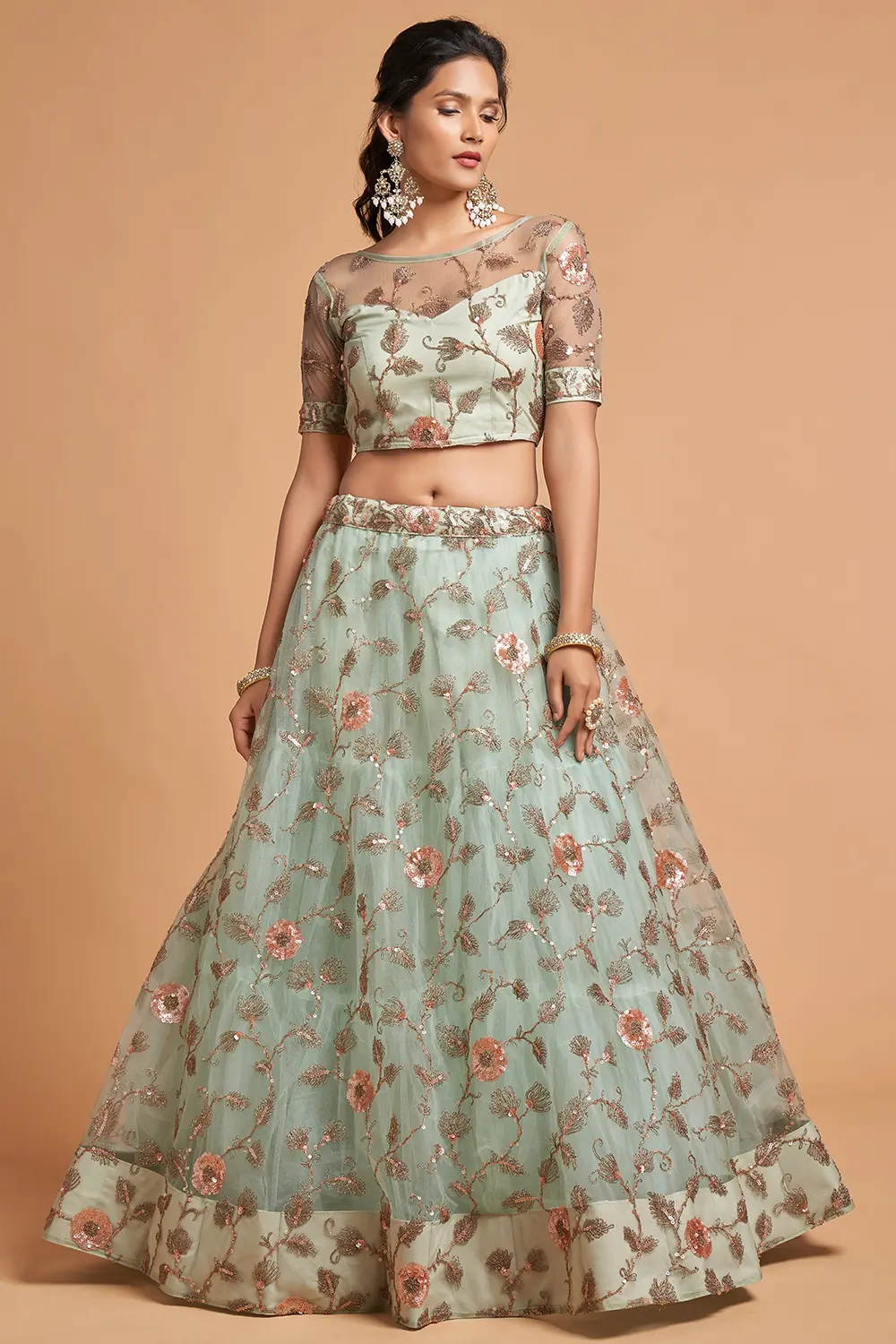 Flat lay of the Sky Blue Net Lehenga set with a coral organza dupatta, shell clutch, and floral jewellery.