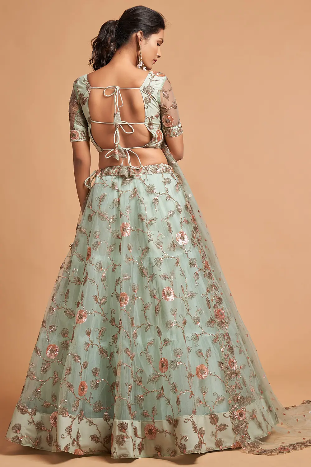 Back view of the plus-size-friendly blouse with fabric-button placket and soft net drape.