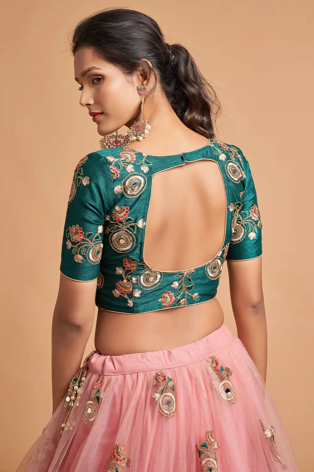 Flat lay of the Peach Net Lehengas with an antique gold dupatta, terracotta potli, and fresh mogra.