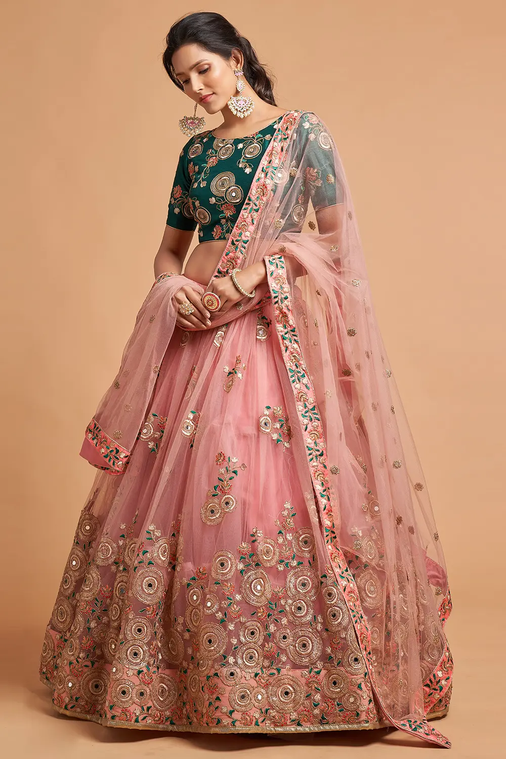 A bride twirling under a tree, wearing the Peach Net Lehengas set, capturing the airy movement.