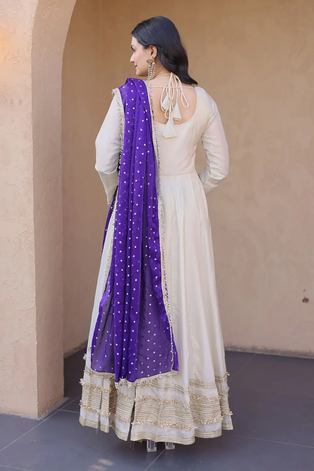 Side view of ivory anarkali gown showing kali pattern flair and sleeves