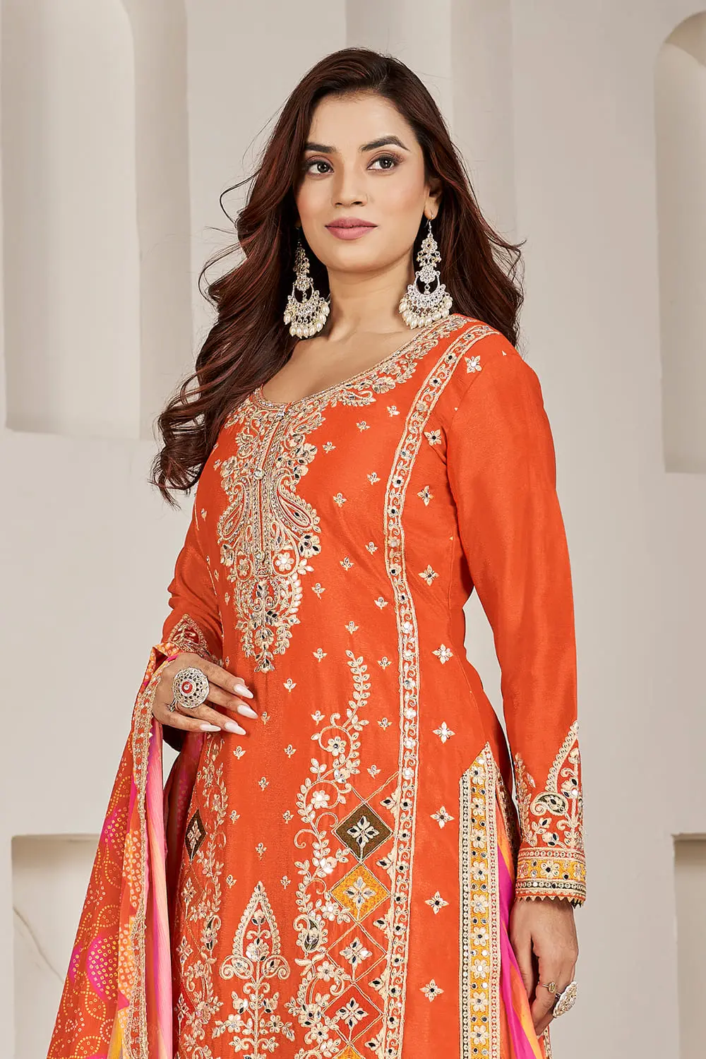 Close up of orange kurti sleeve with sequins and shisha mirror embroidery