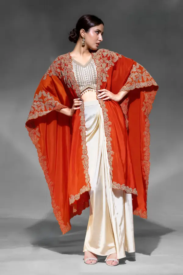 Indo western party wear for women in orange crepe with embroidered shrug by Khaish