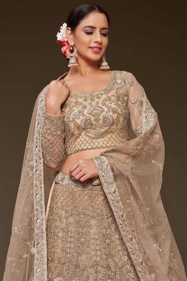 Gold soft net lehenga styled with embroidered blouse and dupatta