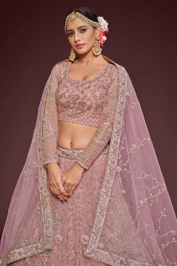 Rose gold soft net lehenga styled with embroidered blouse and dupatta