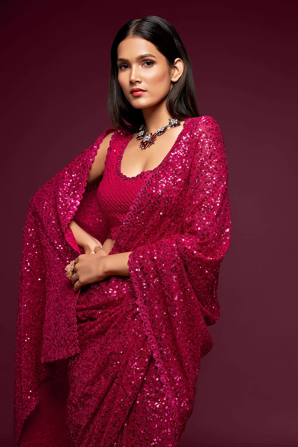 Close up of thread embroidery and multiple sequins on hot pink saree