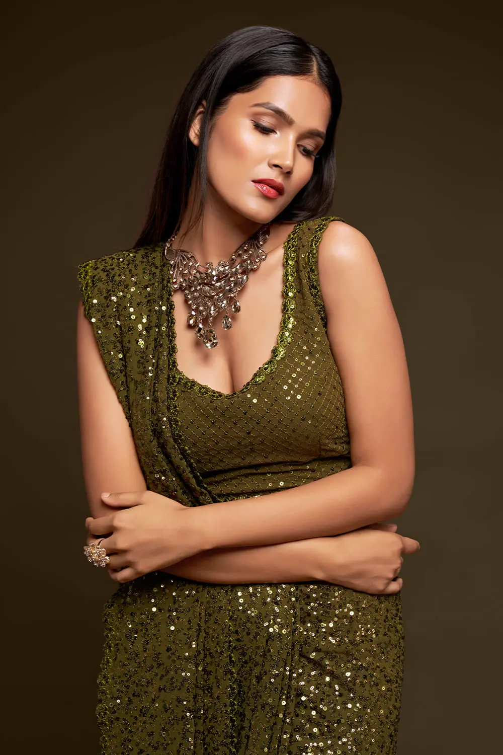 Close up of thread embroidery and multiple sequins on olive green saree
