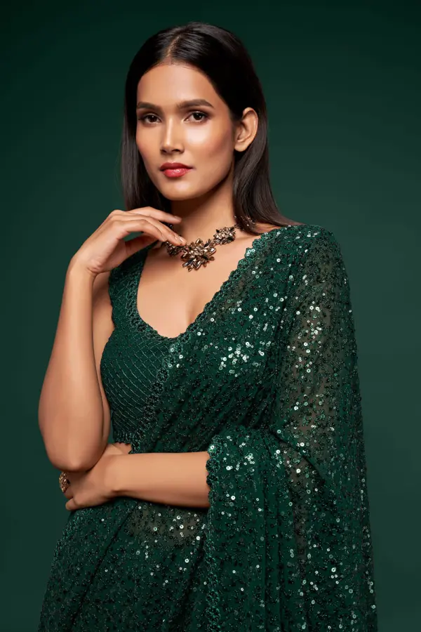 Close up of thread embroidery and multiple sequins on deep green saree