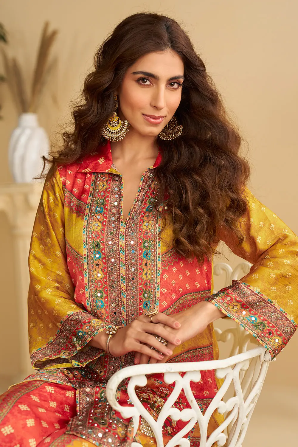 Close up of hand mirror work and cord embellishment on orange and yellow crepe silk kurta