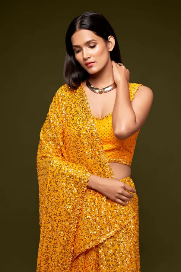 Close up of thread embroidery and multiple sequins on honey yellow saree