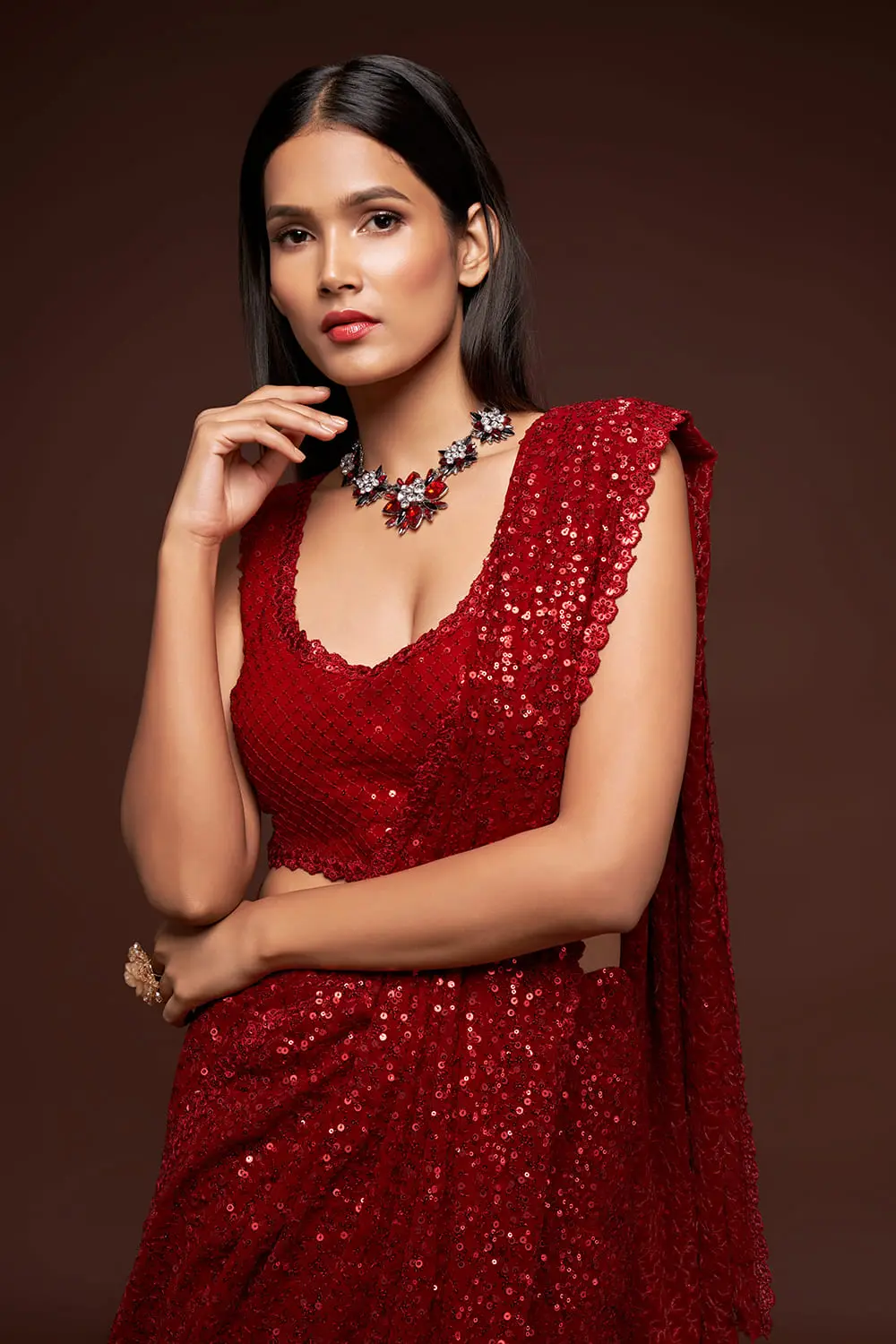 Close up of thread embroidery and multiple sequins on ruby red saree