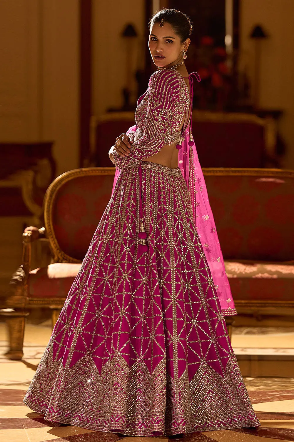 Back full view of hot pink silk lehenga with embroidered silk dupatta draped