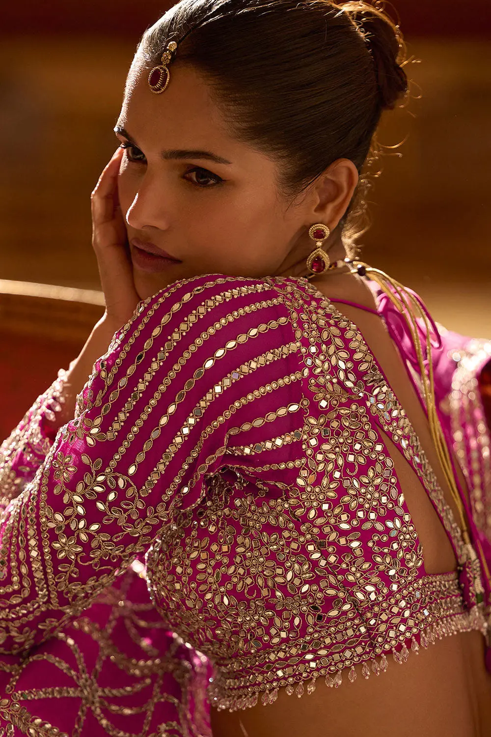 Back close up of hot pink silk dupatta embroidery and lehenga upper back