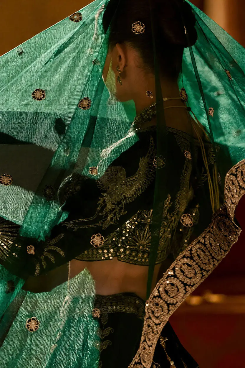 Close up of deep green silk lehenga embroidery where blouse and lehenga meet