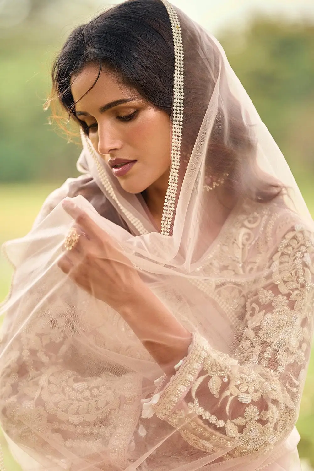Close up of diamond touch-up stones alongside bead embroidery on dusty pink net kurta top