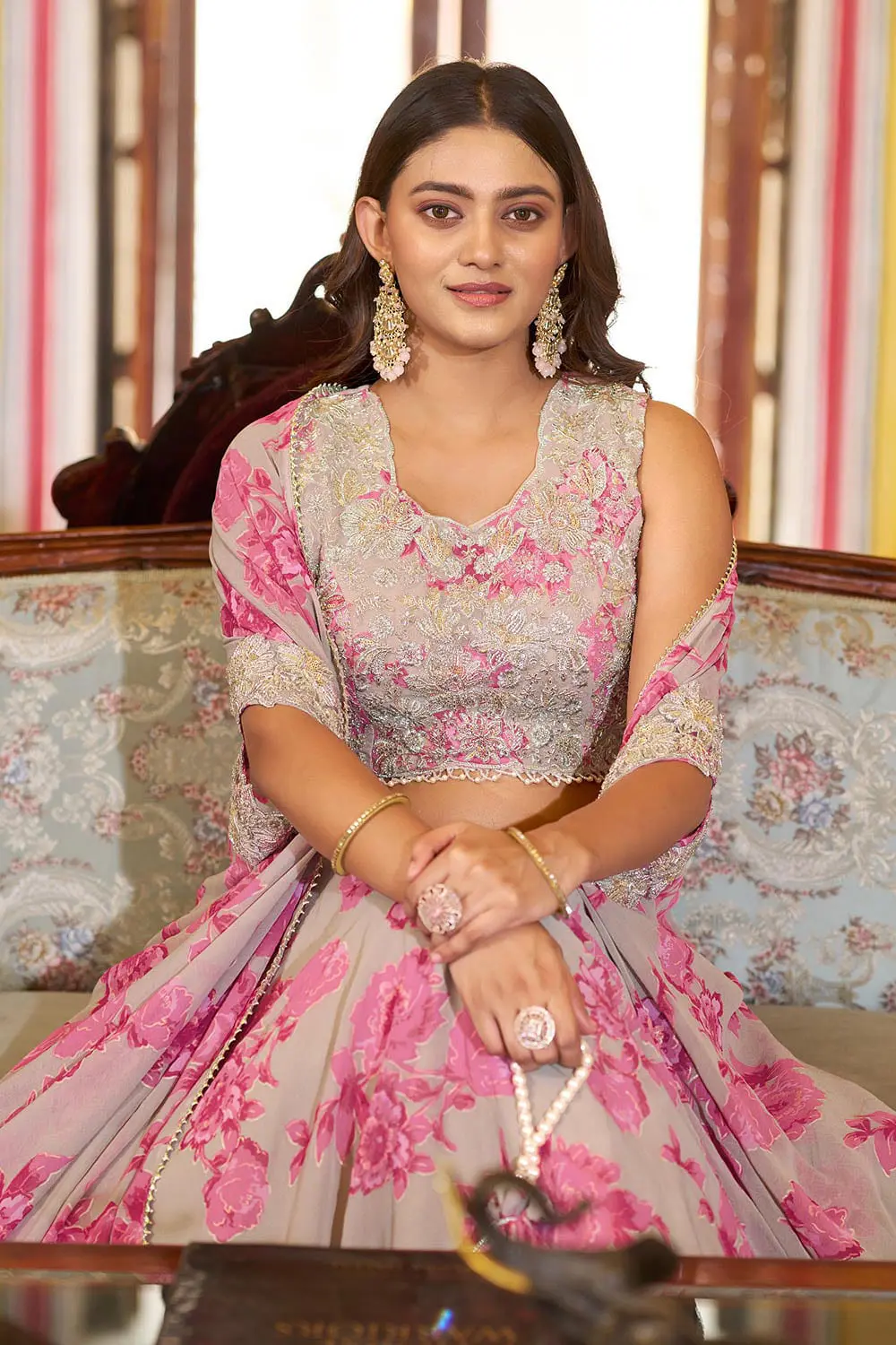 Pink floral cape lehenga with thread embroidery seated view
