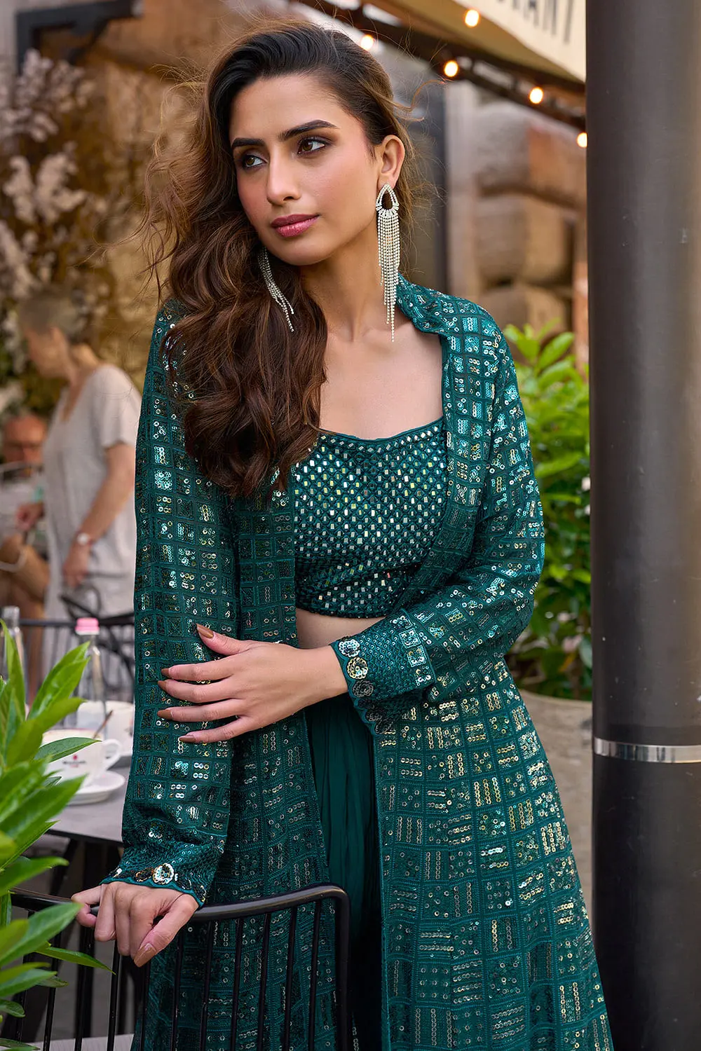 Close up of teal blue embroidered blouse neckline and palazzo detail beneath the jacket hem