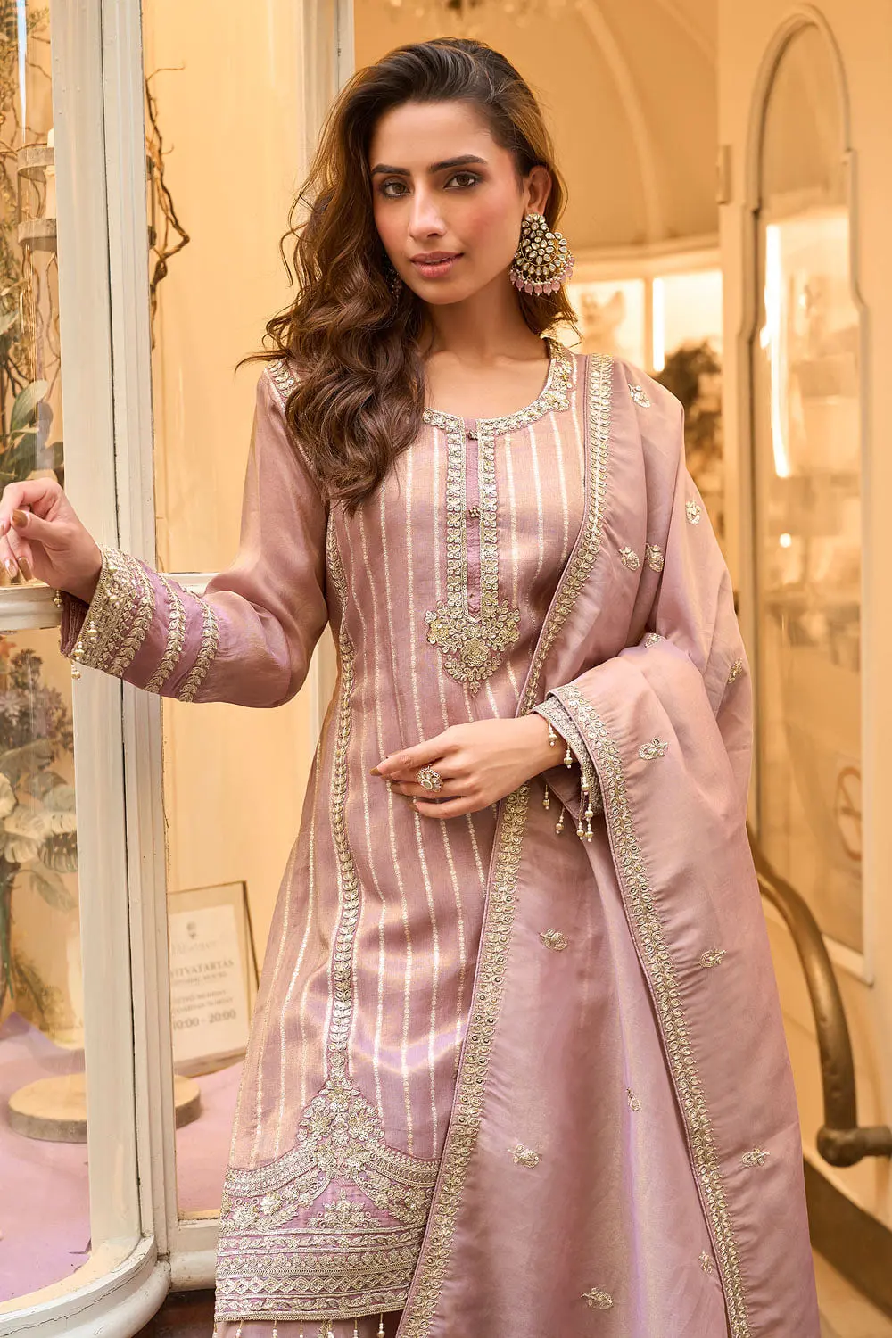 Woven shimmer thread in the mauve jacquard fabric close up alongside embroidered surface detail