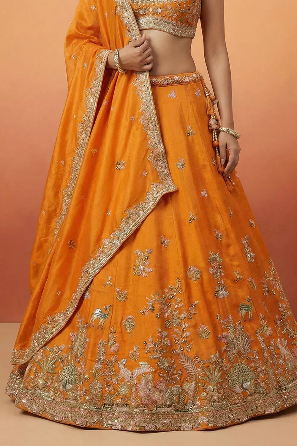 Hemline of the orange lehenga, cutwork openwork visible against the can-can flare