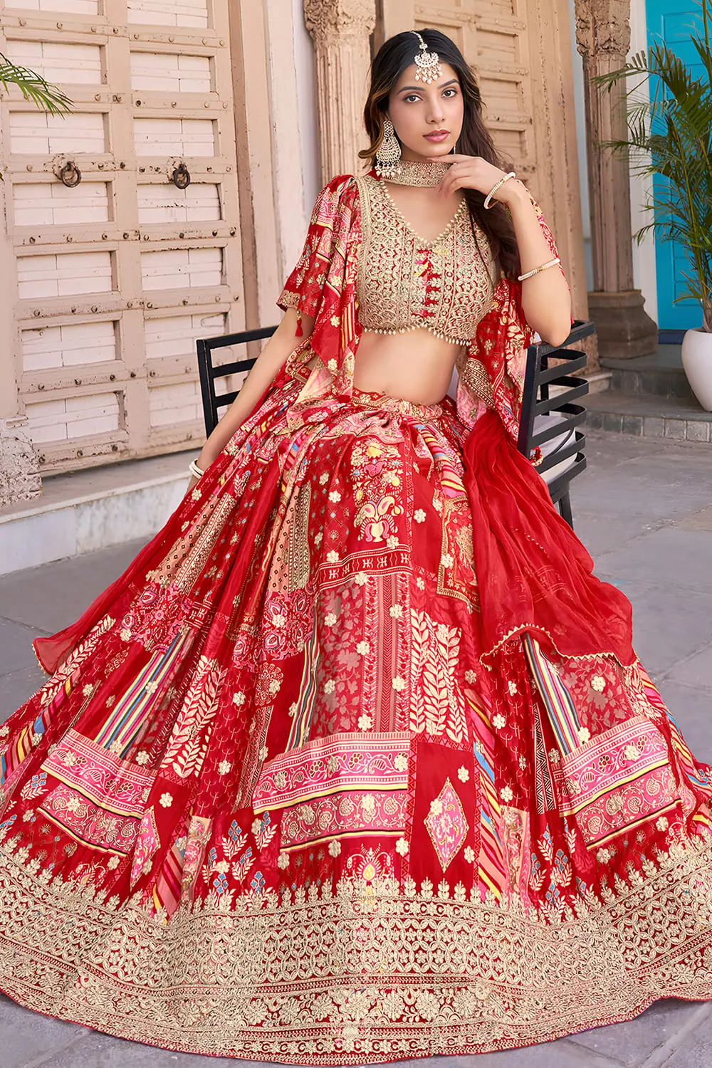 Front-facing view of the red lehenga's flare, chiffon dupatta draped loosely at the shoulder