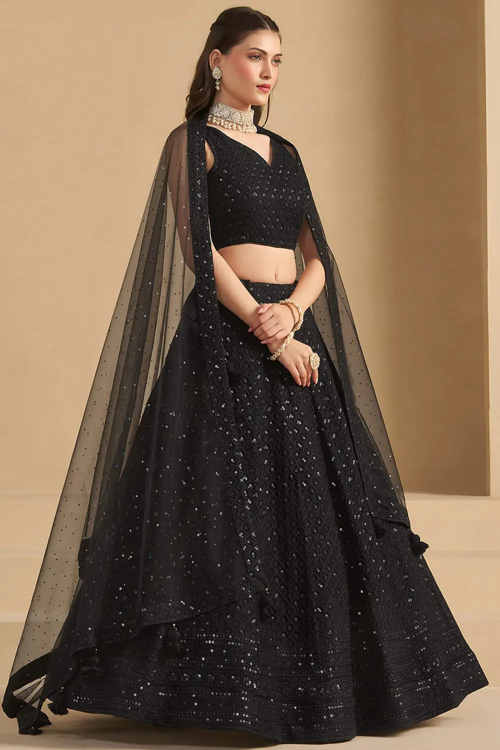 Side profile of black georgette lehenga with net dupatta draped