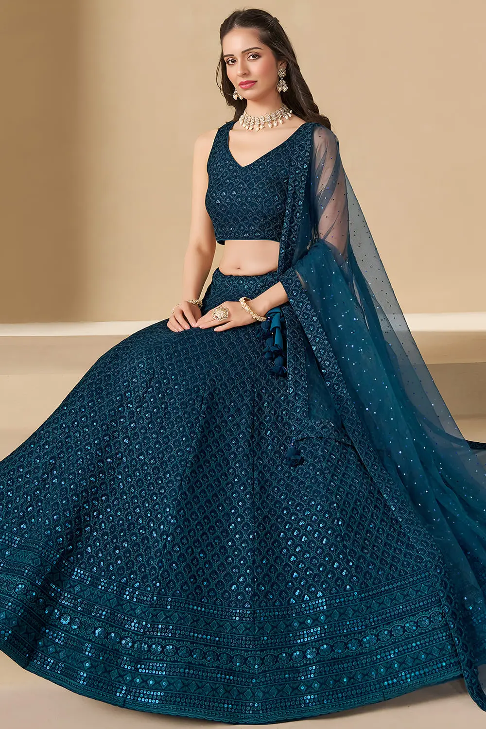 Woman sitting gracefully in a flowing blue ethnic skirt and soft net dupatta