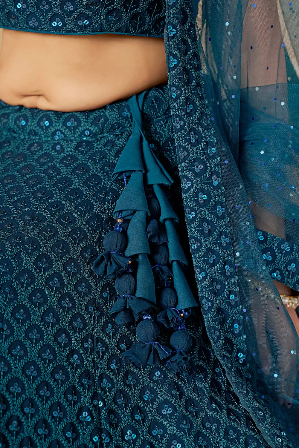 Detailed view of the decorative side dori and tassels on the blue skirt