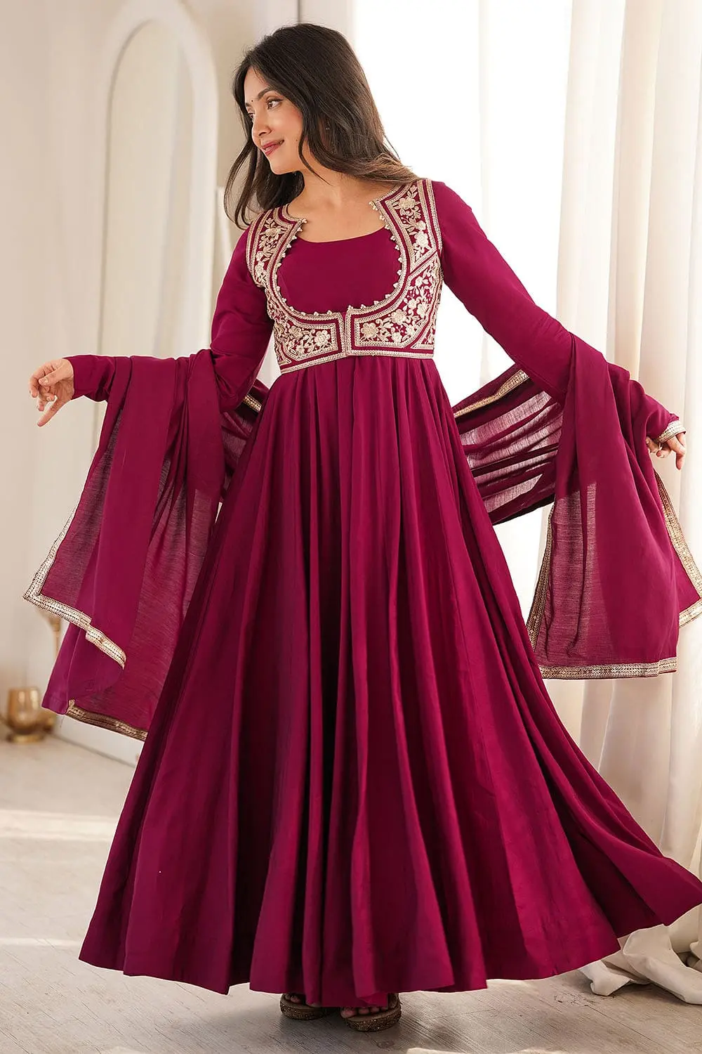 Full length shot of pink floral Indian wedding guest outfit layered with a jacket