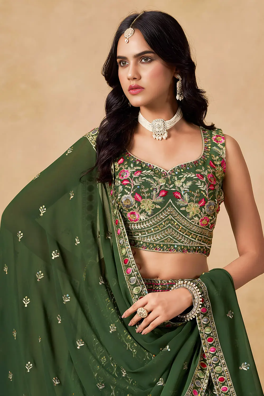 Close up of sequins and thread embroidery on green georgette lehenga