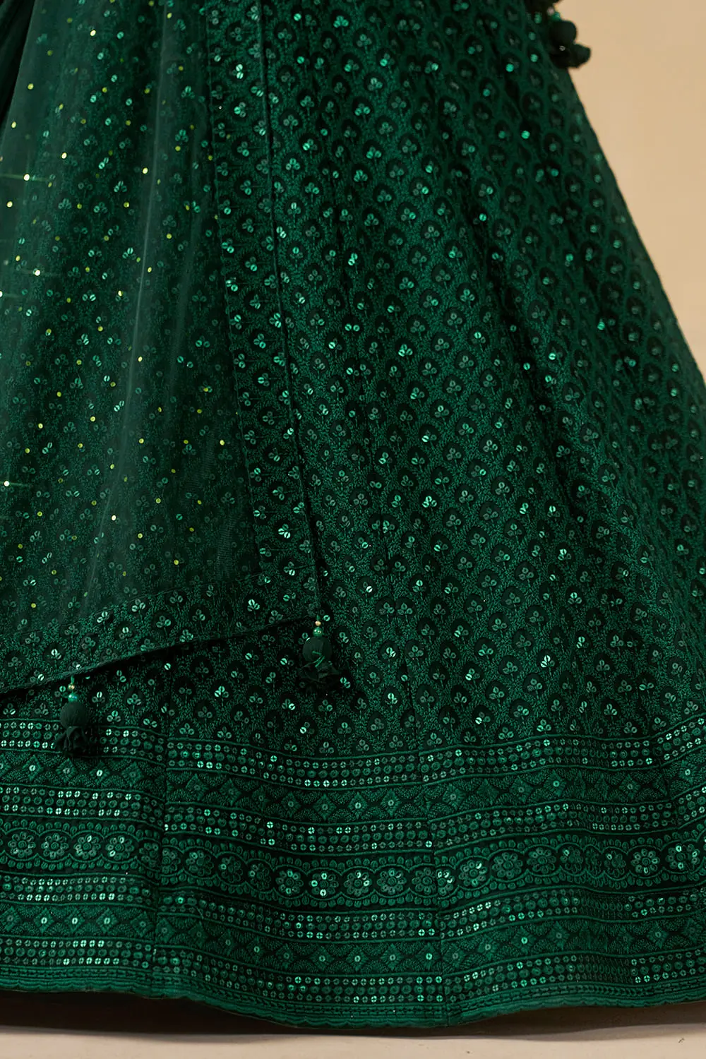 Detailed view of the bottom hem and heavy sequin border on the green skirt