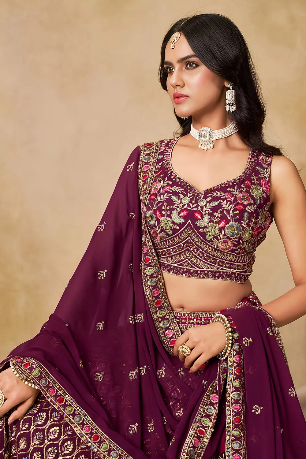 Close up of sequins and thread embroidery on maroon georgette lehenga