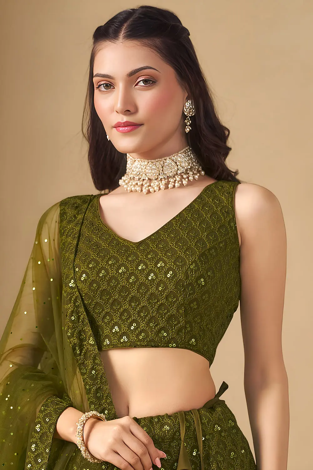 Close up of complex sequin and thread embroidery on the olive green georgette blouse