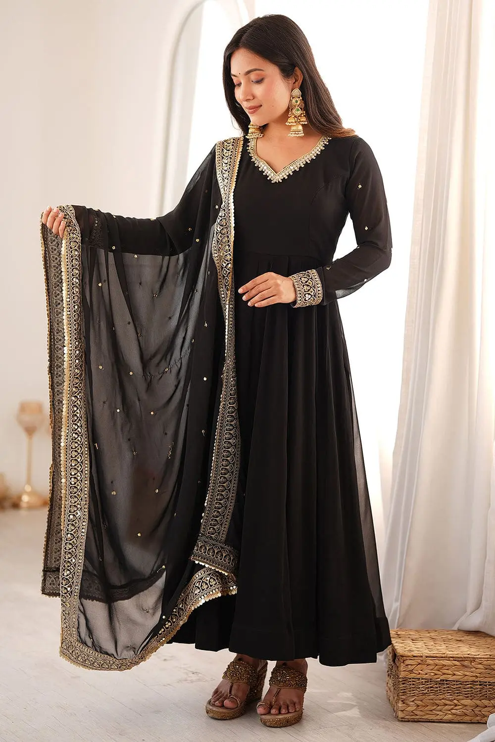 Elegant draping of the matching dupatta on the black georgette anarkali set.